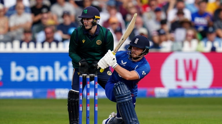 England's Ben Duckett bats watched by Ireland wicketkeeper Lorcan Tucker...