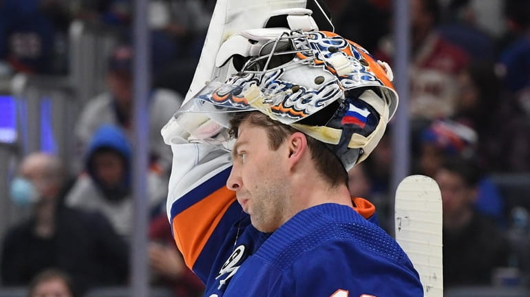 Islanders goaltender Semyon Varlamov adjusts his face mask against the...