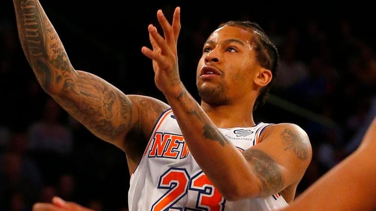 Trey Burke of the Knicks goes to the hoop for...