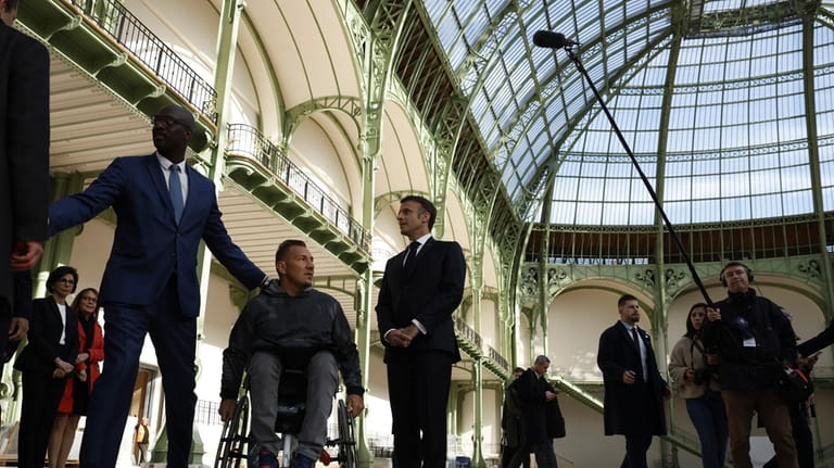 French. President Emmanuel Macron, center, visits the Grand Palais ahead...