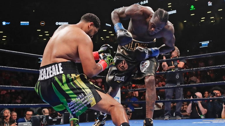 Deontay Wilder, right, knocks down Dominic Breazeale during the first...
