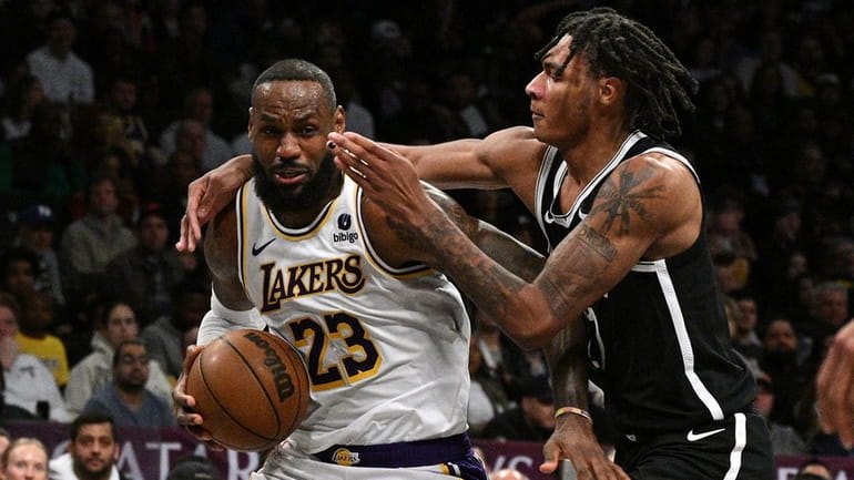 Lakers forward LeBron James is fouled by Nets forward Noah...