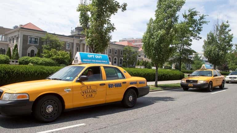 Nassau taxi drivers circle the Nassau County Executive Building in...