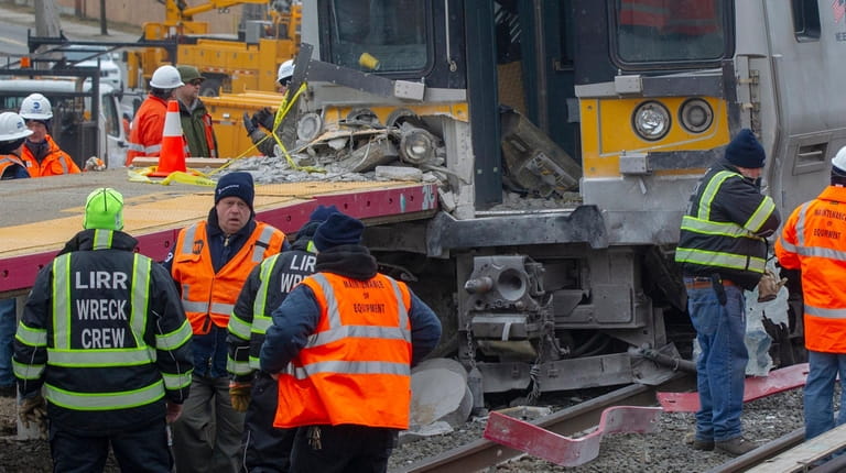 Work crews assess the damage at the Westbury crash scene on...