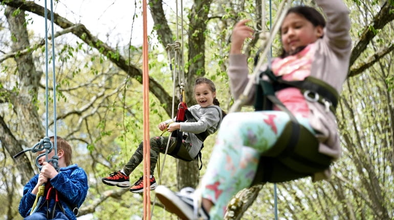 Camille Pop Smirnoff, 6, of Douglaston, center, climbs a tree...