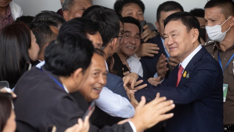 Thailand's former Prime Minister Thaksin Shinawatra, second right, is greeted...