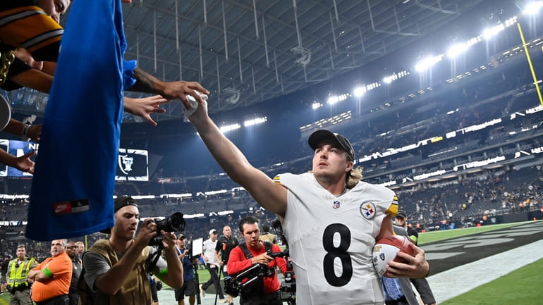 Pittsburgh Steelers quarterback Kenny Pickett gives his glove to a...