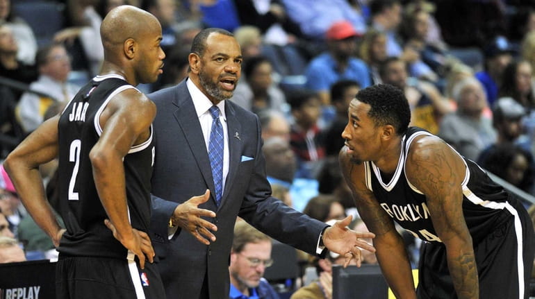 Brooklyn Nets head coach Lionel Hollins, center, talks with guard...
