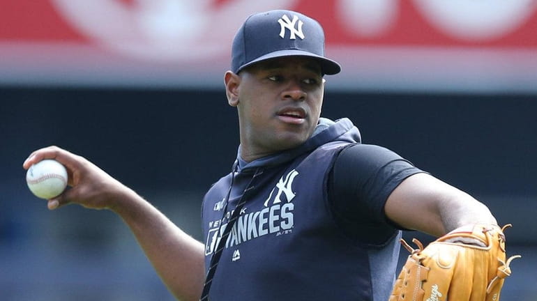 Yankees pitcher Luis Severino throws in the outfield before a game...