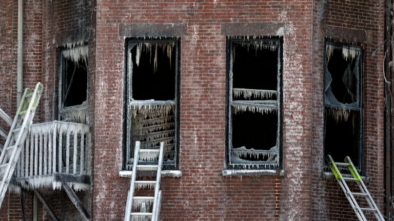 Ladders lean against burned remains of a four-story brownstone, March...