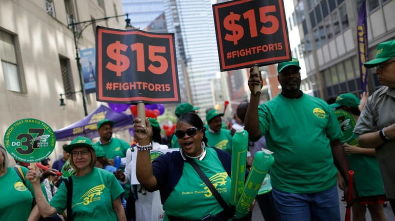 Activists cheer after the New York Wage Board endorsed a...