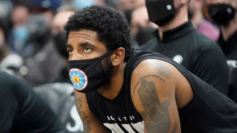 Nets guard Kyrie Irving looks on from the bench in...