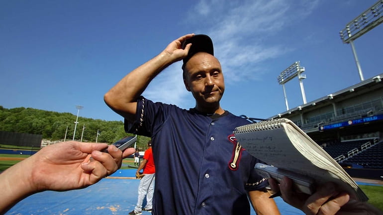 Derek Jeter talks with reporters during pregame warmups before his...