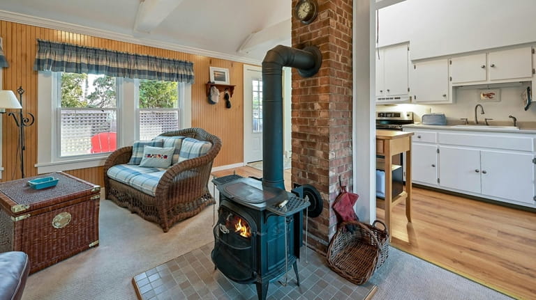 A wood-burning stove attached to a red-brick column is a...