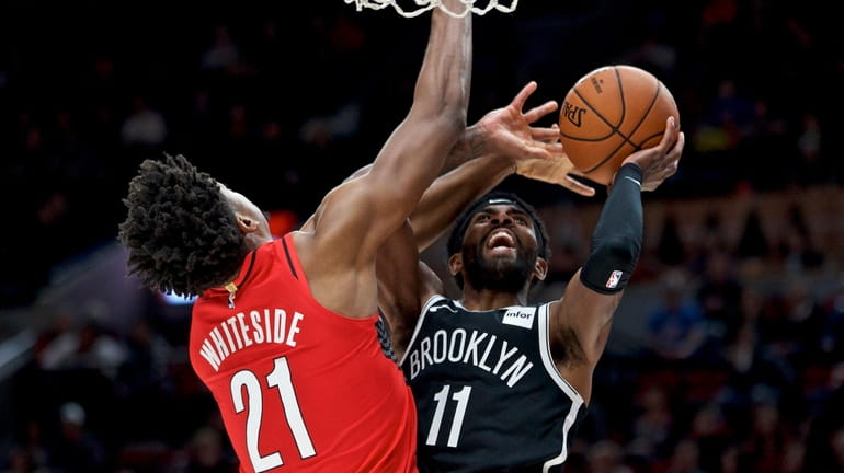 Nets guard Kyrie Irving, right, shoots over Portland Trail Blazers...