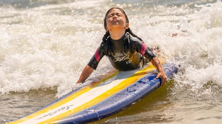 Emilia Alberi, 5, of East Hampton takes a surfing lesson...
