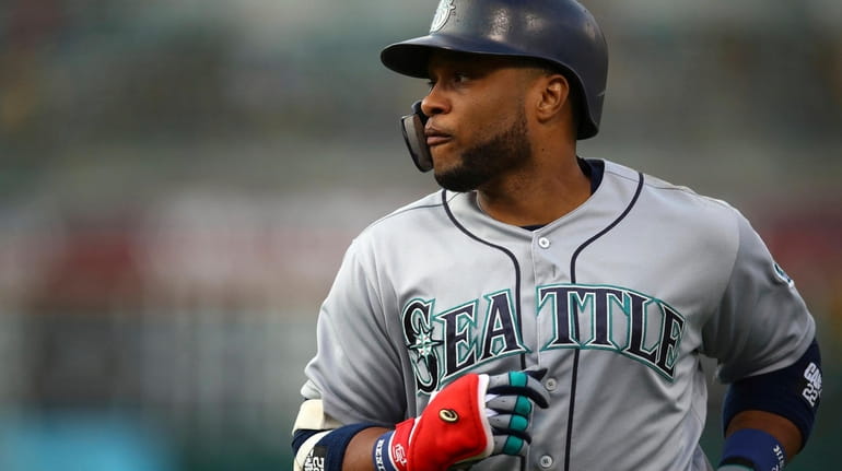Seattle Mariners' Robinson Cano runs to the dugout after grounding...