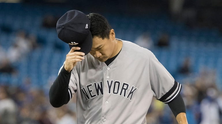 Yankees starting pitcher Masahiro Tanaka comes off the field at...