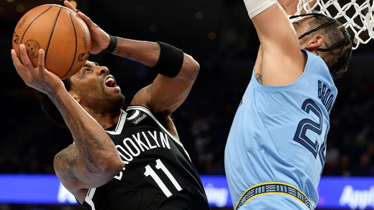 Nets guard Kyrie Irving shoots against Grizzlies forward Dillon Brooks during...