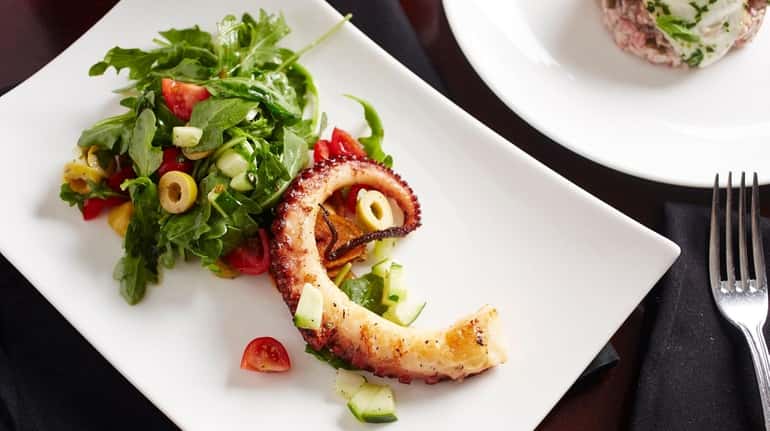 Grilled octopus with baby arugula and fingerling potatoes is still...