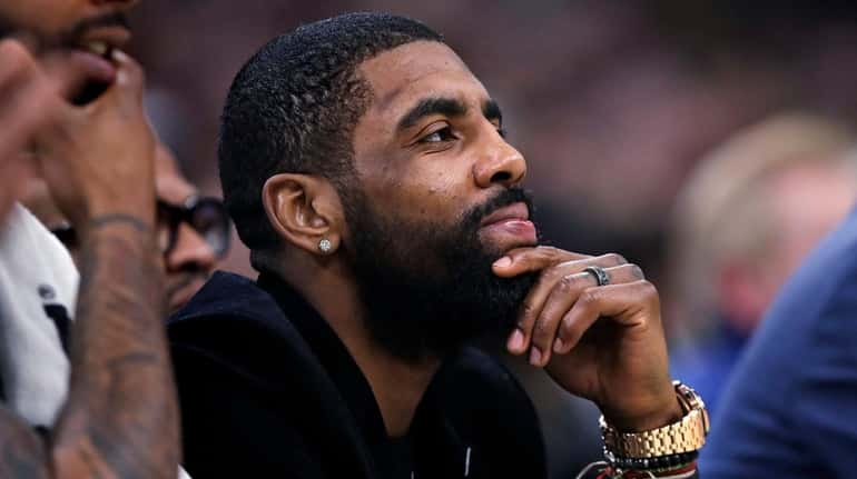 Celtics guard Kyrie Irving watches play from the bench uring...