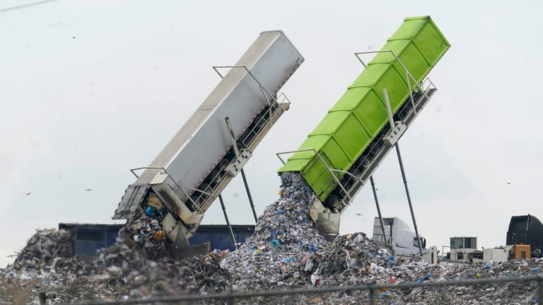 Garbage is loaded into a landfill in Lenox Township, Mich.,...