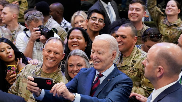 President Joe Biden takes a selfie during a visit to...