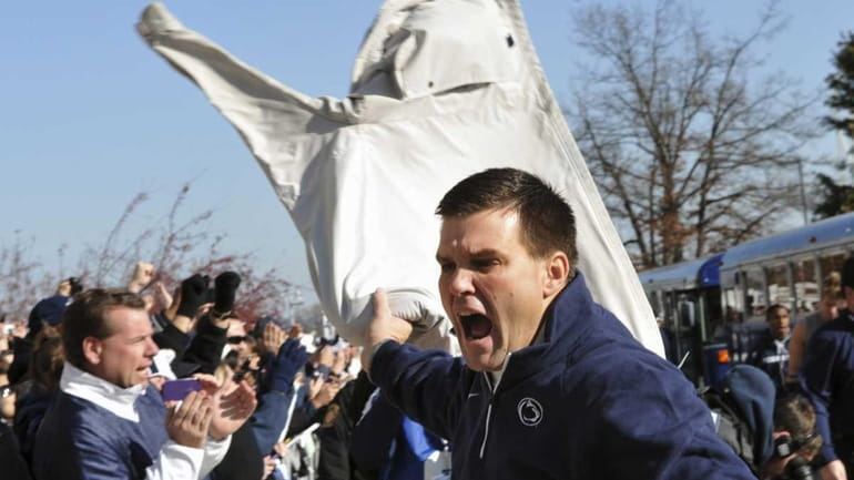 Penn State assistant coach Jay Paterno waves his father's jacket...