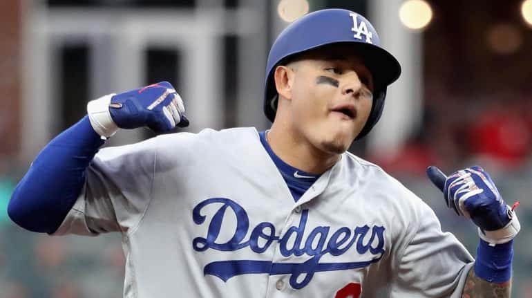 The Dodgers' Manny Machado celebrates as he rounds the bases after...