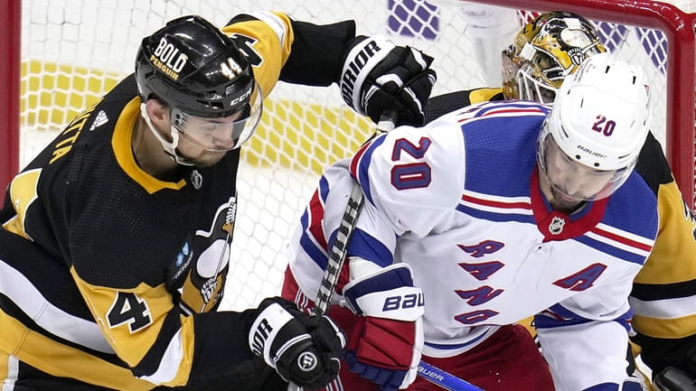 Pittsburgh Penguins' Jan Rutta defends New York Rangers' Chris Kreider...