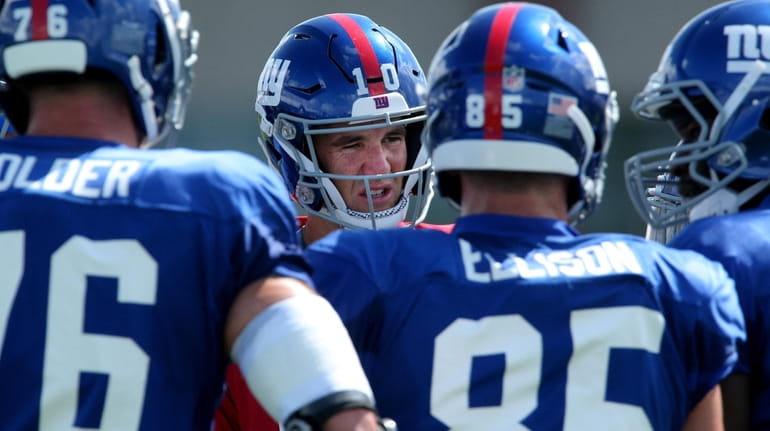 Giants quarterback Eli Manning talks to teammates during training camp at...