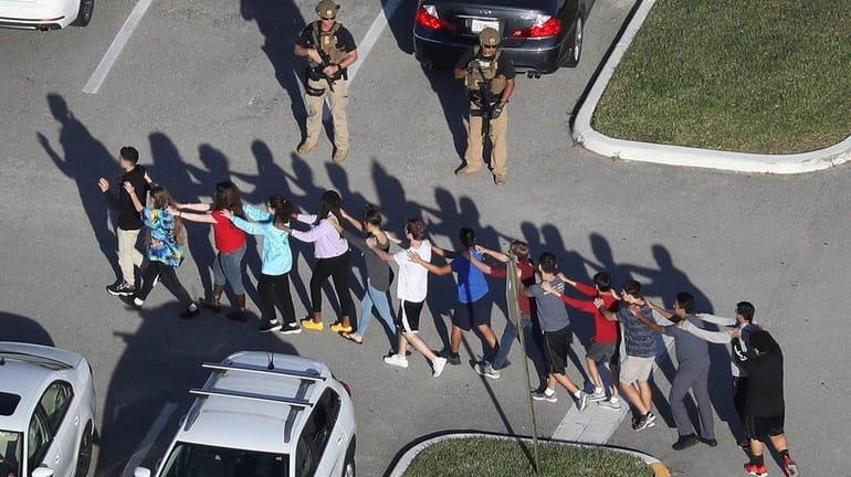 People leave Marjory Stoneman Douglas High School after a shooting...
