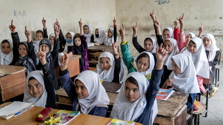 Afghan school girls attend their classroom on the first day...