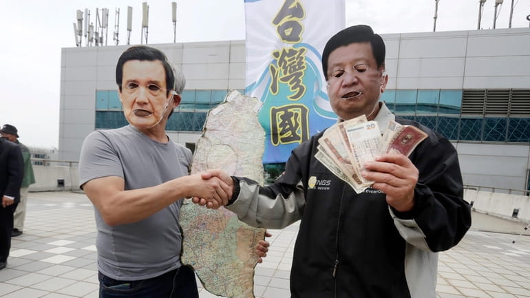 Protesters wearing masks of former Taiwanese President Ma Ying-jeou, left,...
