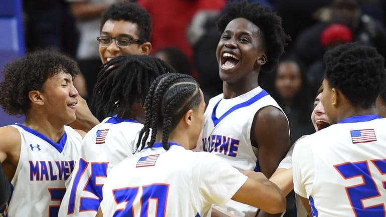 Malverne teammates celebrate after their 60-36 win over Carle Place...