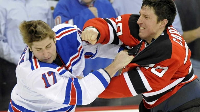 New Jersey Devils' Ryan Carter, right, fights with Rangers' Brandon...