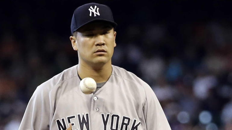 Yankees starting pitcher Masahiro Tanaka waits to throw after giving...