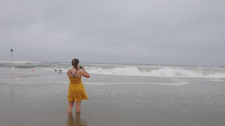 Molly Brown, 17, of Westhampton Beach, photographs waves at Pikes...
