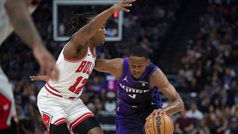 Chicago Bulls guard Ayo Dosunmu defends Sacramento Kings guard De'Aaron...