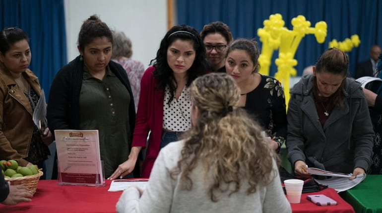 Job seekers speak with a recruiter during a May 3 job...