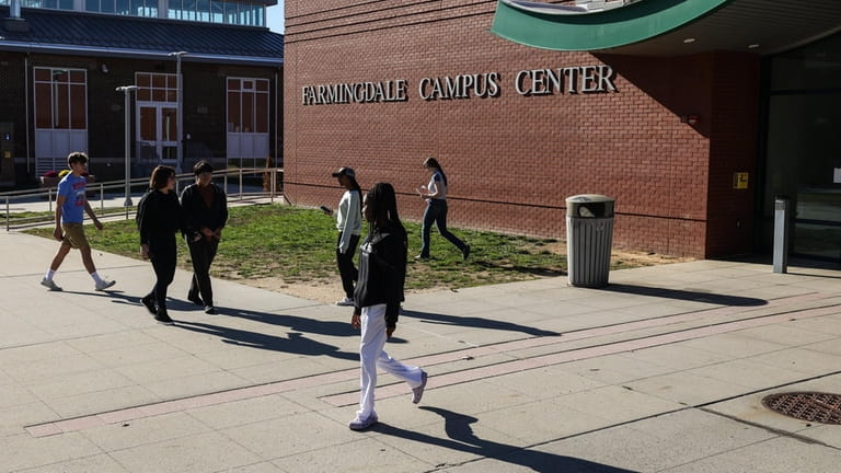 Students walk the campus of Farmingdale State College, in East...