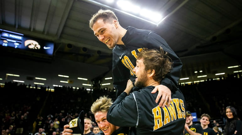 FILE - Iowa's Spencer Lee is lifted up onto the...