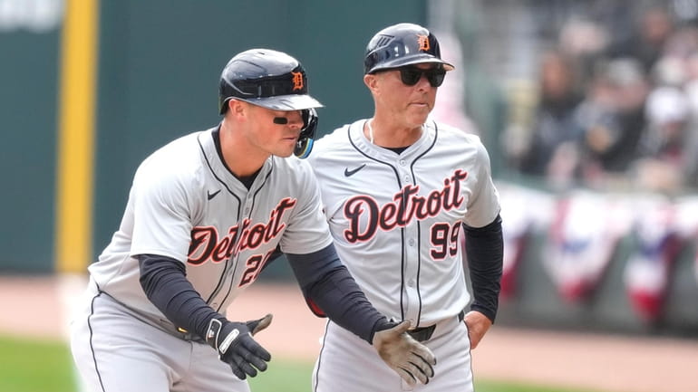 Detroit Tigers' Mark Canha, left, and first base coach Anthony...