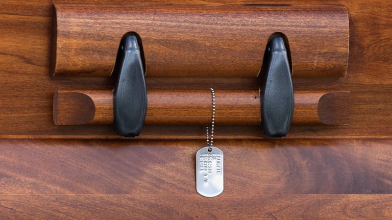 A military "dog tag" adorns the coffin carrying the remains of World War...