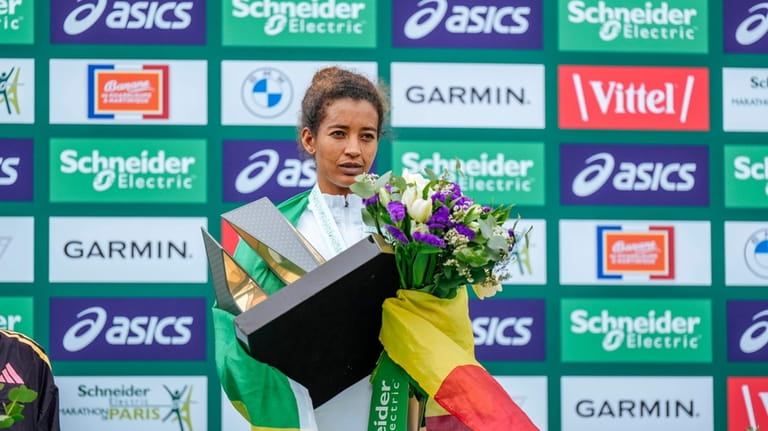 Mestawut Fikir of Ethiopia holds her trophy on the podium...
