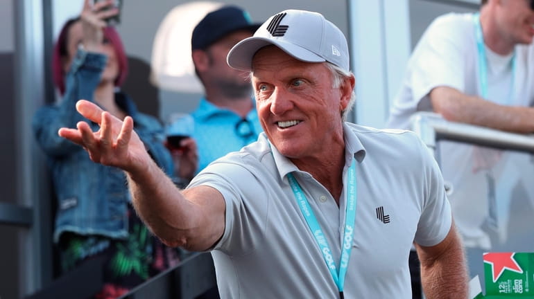 Greg Norman, CEO of LIV Golf, tosses a beer to...