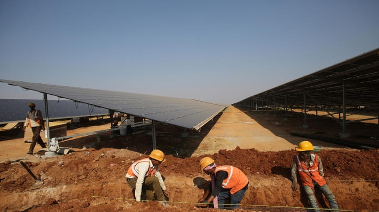 Laborers work at the Pavagada Solar Park north of Bangalore,...