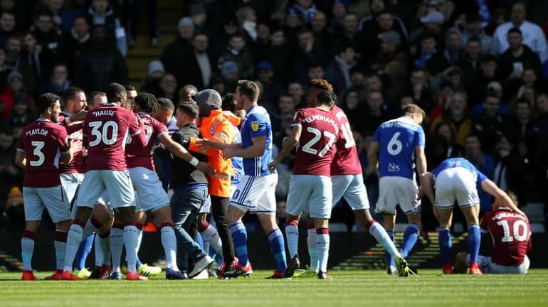 A fan is removed after attacking Aston Villa's Jack Grealish,...