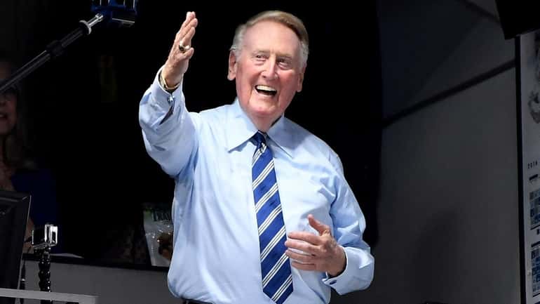 Los Angeles Dodgers announcer Vin Scully greets the crowd before...