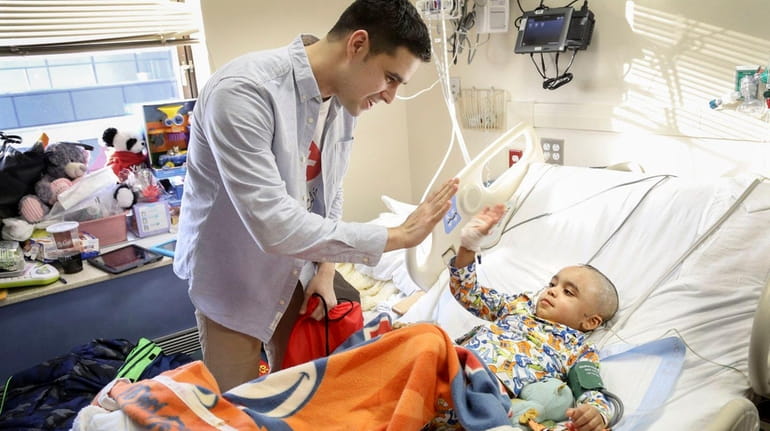Stony Brook medical student David Elkin visits patient Christian Feliciano,...